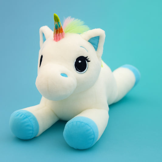 Plush unicorn toy with a rainbow horn on a light blue background